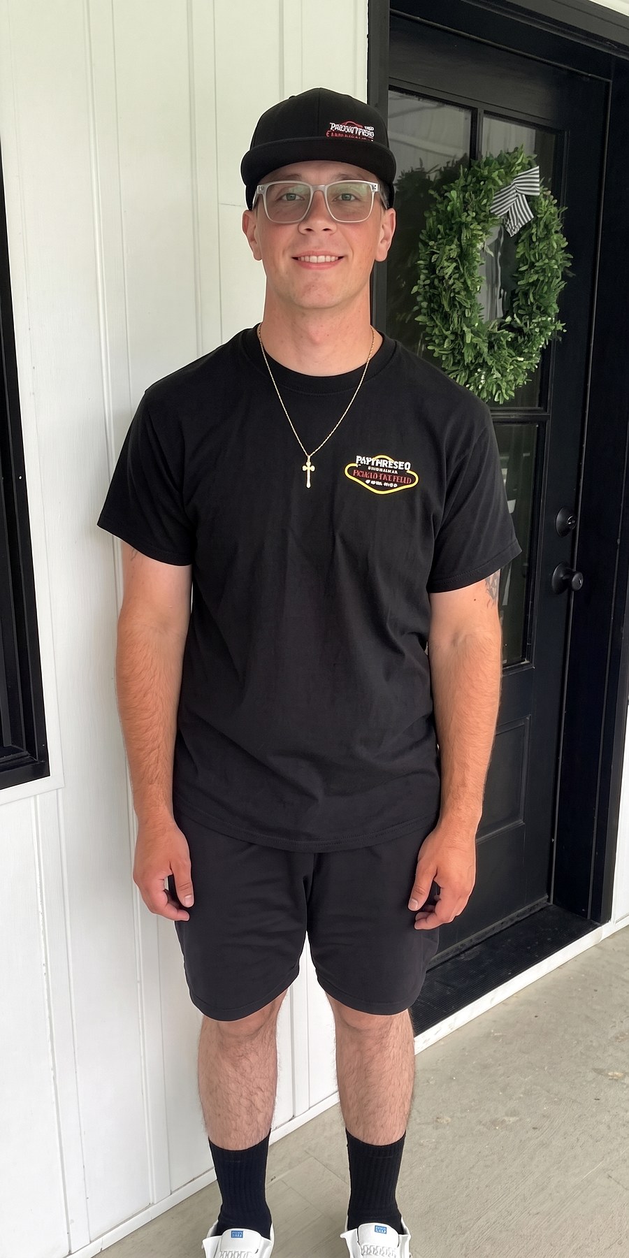 After, standing by the front door in a black cap and t-shirt