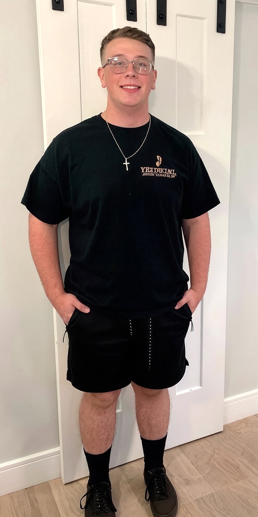 Before, standing in a doorway in a black t-shirt